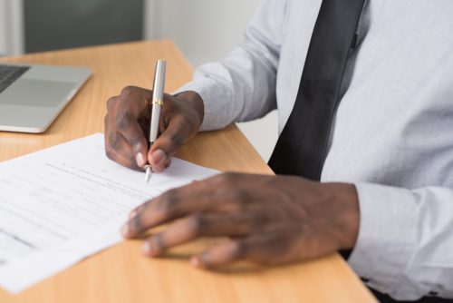 man signing document