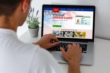 man on computer screen with green card