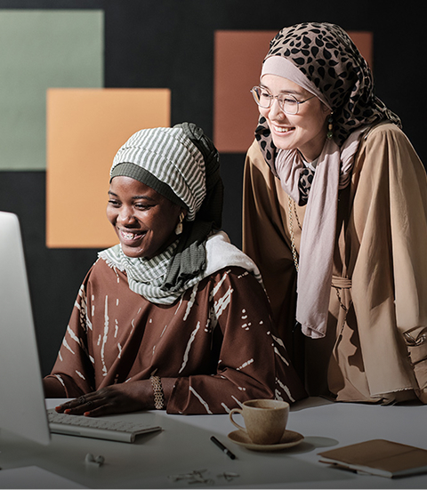 two Muslim businesswomen working together at the table at office