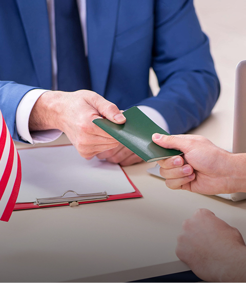 person in suit handing green card to client
