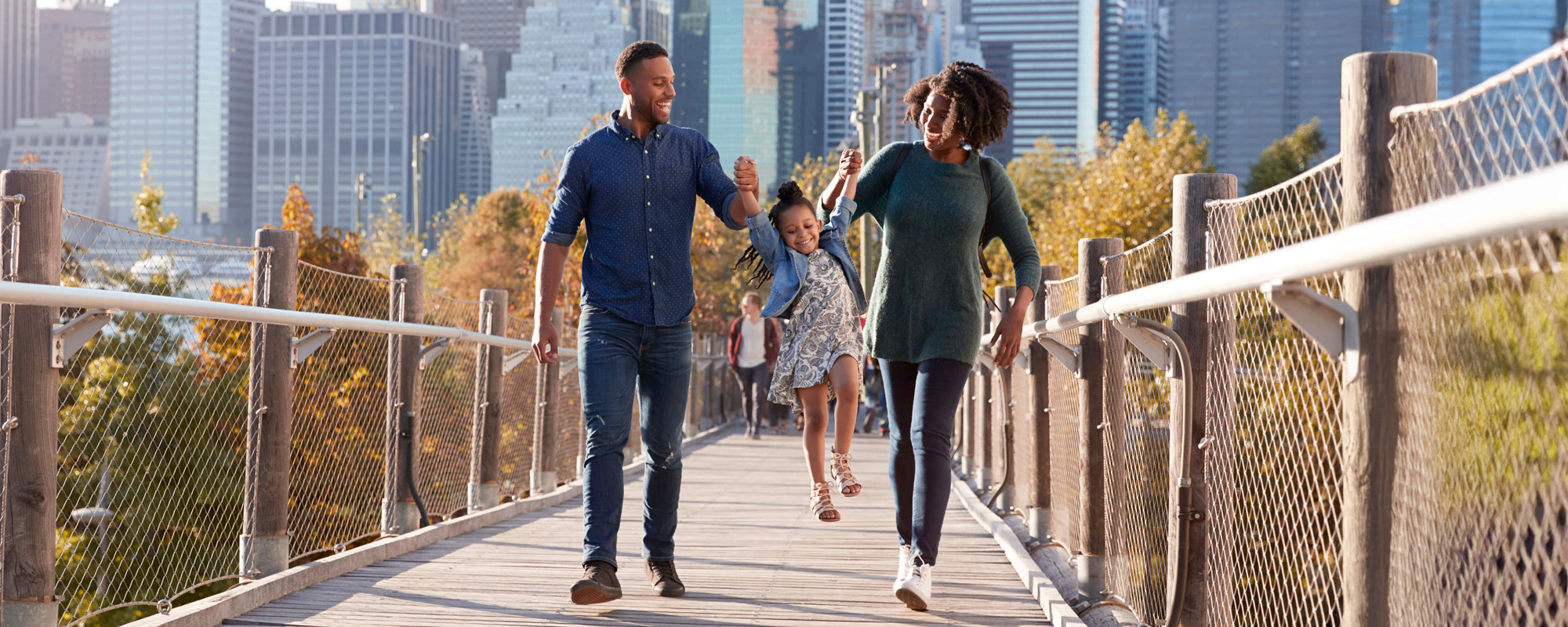 family walking across a bridge in new york city