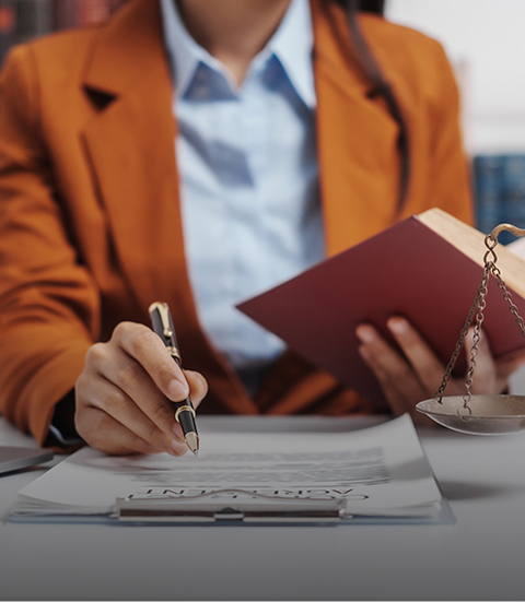 female lawyer filling out documents and holding a book