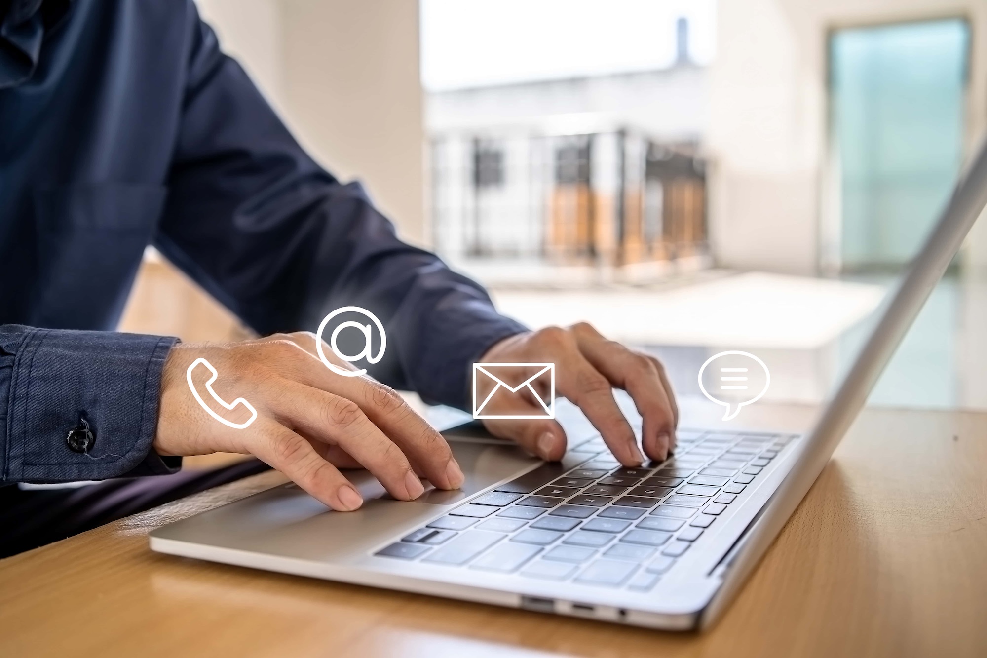 typing on laptop with contact icons floating above